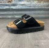 Black sandal with cork sole on a textured surface